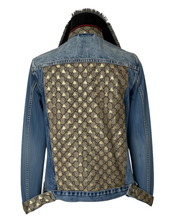 Load image into Gallery viewer, A  denim jacket shown from the back, featuring a large beige and brown GG monogram pattern panel across the back, blue denim sleeves and shoulders, and matching monogram pattern on the turned-up cuffs.
